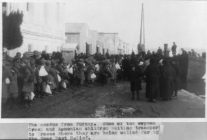 Armenian and Greek Families, men, women, and children leaving Turkey after the genocide. People are holding sacs and bags with their personal belongings. People are waiting for the aid of the Near East Relief.