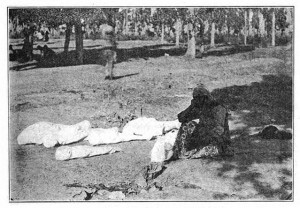 Mother with her dead children, the Armenian cry after the genocide. In the photo, the mother sitting down on the floor with her dead children wrapped in white cloths laying on the ground in the woods.