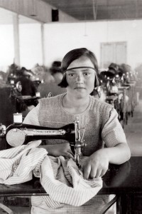 Young girl working at a sewing machine in an orphanage workshop in Syra, Greece. The orphans sewed clothing and linens for the orphanage and for sale in the community. All profits went toward the orphanage. This photograph also appeared in a Near East Relief promotional booklet.