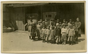Near East Relief orphans originally from Aintab waiting at a garage in Beirut. According to Nellie Miller's original notes, the children are preparing to leave for the orphanage at Ghazir, Syria.