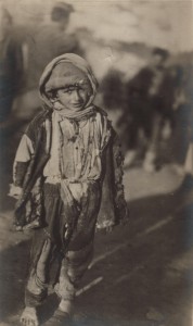 Refugee child  in rags. Children struggled to keep covered in the extreme climate. Many suffered from sunburn and frostbite. Nellie Miller's original caption reads: 