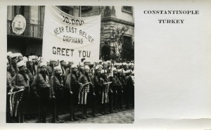 Postcard of Near East Relief orphans in Constantinople. A group of Near East Relief boys in Boy Scout uniforms greet the first large group of American tourists to visit Constantinople since World War I began. Despite the ongoing political situation, the Near East maintained a thriving tourism trade. Visitors from America purchased orphan-made souvenirs and postcards like this one to benefit Near East Relief's work.