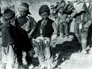Three refugee boys in scavenged clothing.