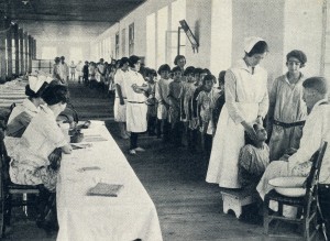 A doctor and three nurses conduct medical examinations in an orphanage hall. Some children received daily medical care, depending upon their health conditions. 