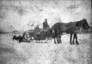 Men and children in a horse drawn sleigh in the winter. The harsh winter conditions in the Caucasus region made automobile travel difficult and impractical. The individuals are unidentified, but they may be relief workers with their own children rather than orphans.