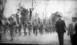 Soldiers walking down a street, date and location unknown. Although the image quality is poor, their rifles are visible.