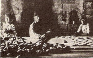 Refugees and older orphans found employment in the Near East Relief bakery in Aleppo, Syria. This particular bakery produced 1,000 lbs. of bread per day. The bread was used to feed Near East Relief orphans and genocide survivors living in Near East Relief-supported refugee camps in and around the city. This photograph was featured in a 1924 New Near East magazine article.