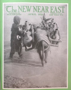 This issue of the New Near East magazine features a stylized image of a young refugee with a laden donkey wading in the water. The location is unknown.