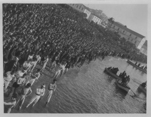 A massive crowd of men on the shoreline in Kavalla, Greece.