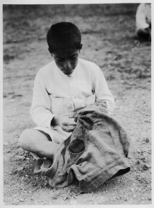 This photograph of a boy repairing a pair of trousers appeared in a Near East Relief publication with this caption: 