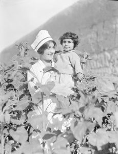 Nurse holding a child in the garden at Alexandropol. The nurse is probably a student or graduate of the Edith Winchester Nursing School at the orphanage.