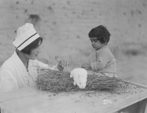 Nurse and child with a rabbit at the orphanage complex at Alexandropol. The young woman may be a student or graduate of the Edith Winchester Nursing School. 