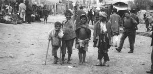 Refugee children on crutches standing in a street