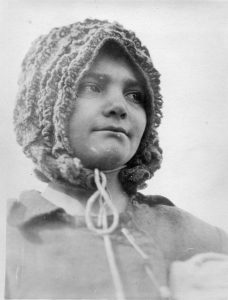Refugee girl wearing crocheted bonnet
