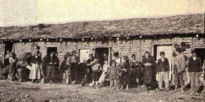 Men, women, and children standing in front of Rodosto cottages